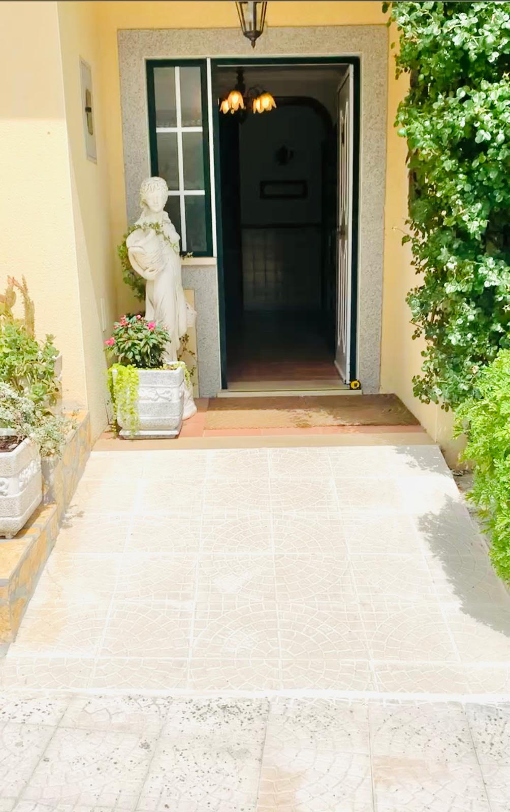 Front entrance of the villa with tiled approach path leading up to the open door