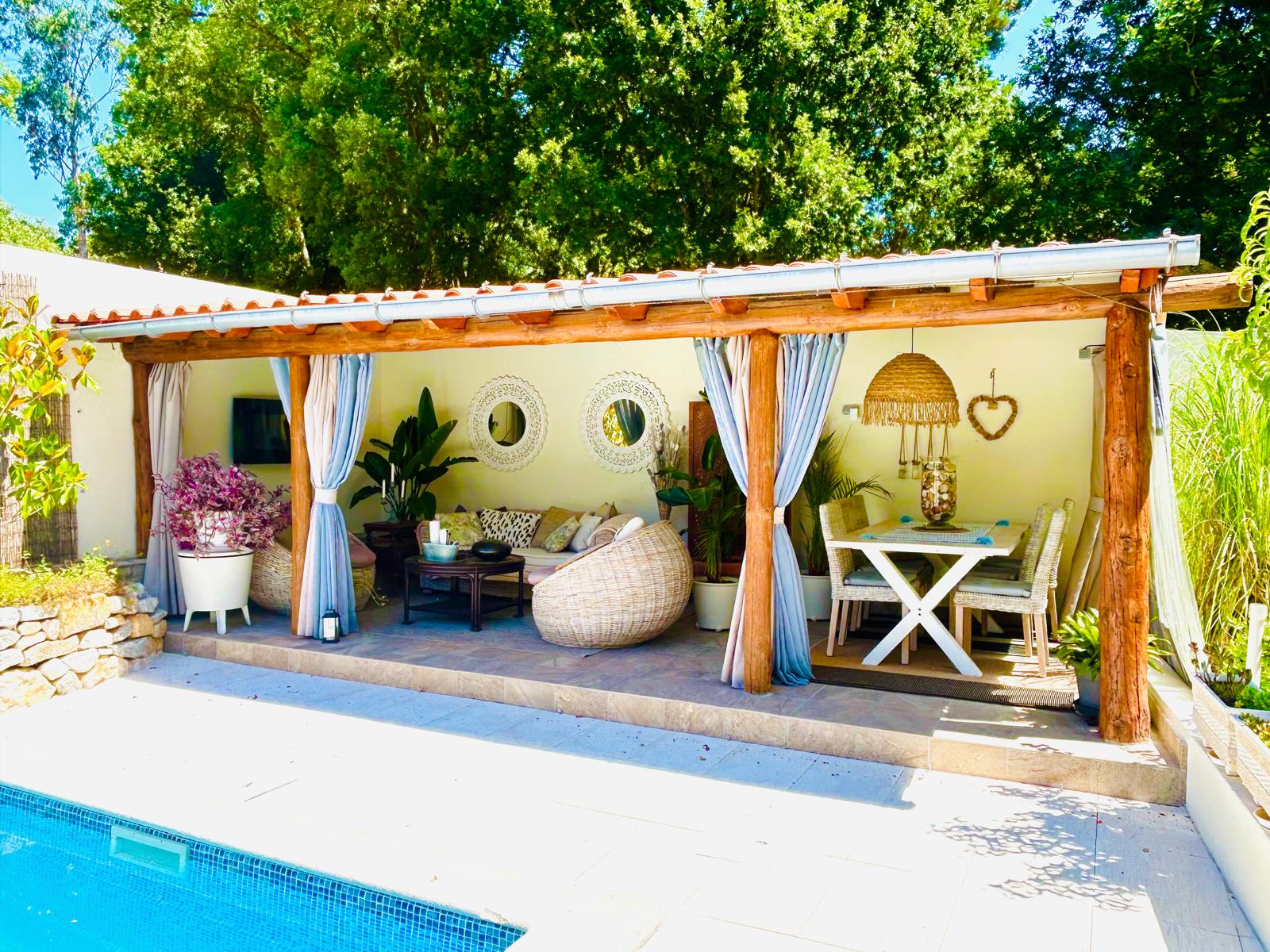 Poolside cabana with wicker seating and dining area