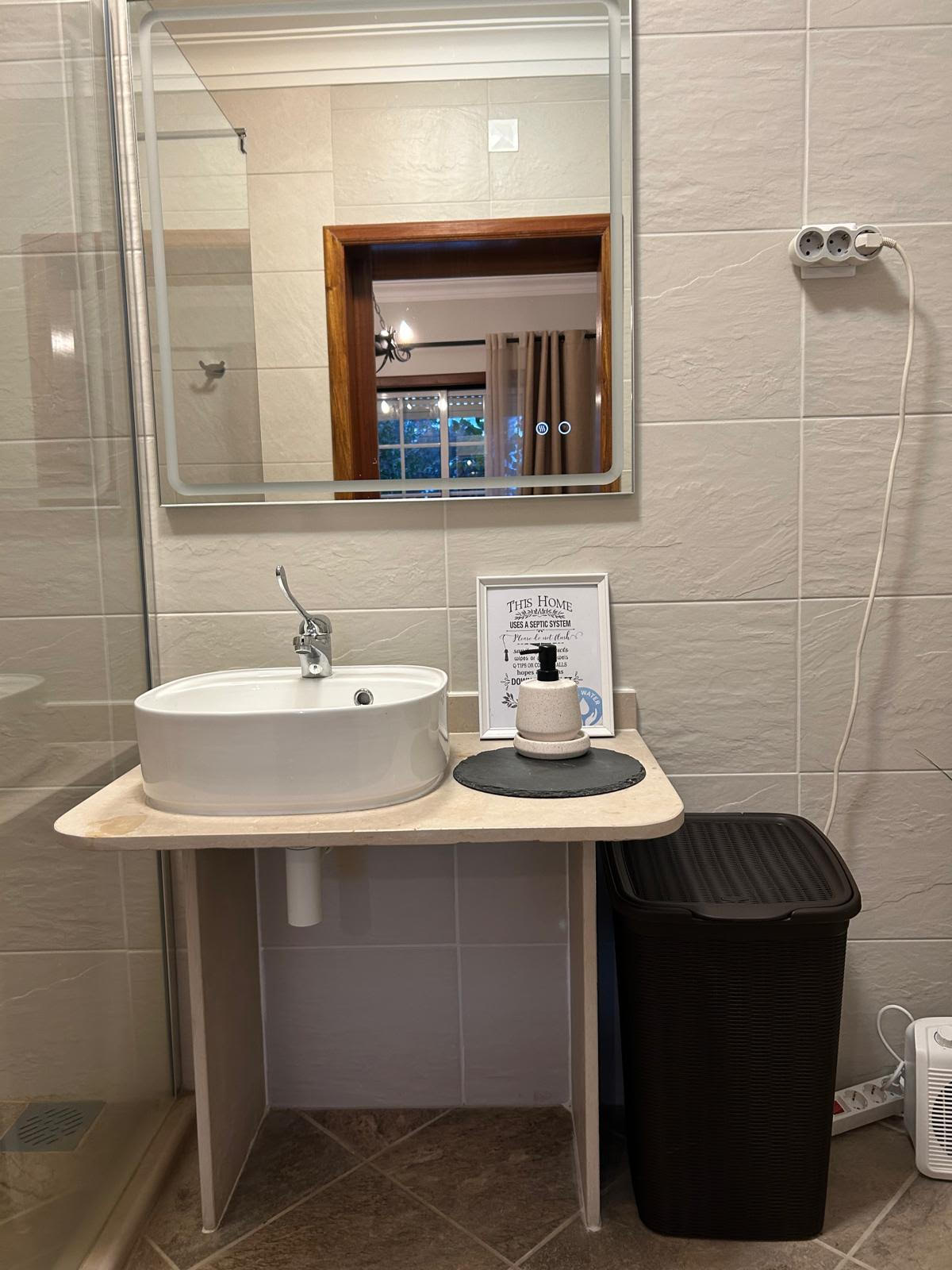 Open-knee sink and vanity in the Sun-Kissed Suite bathroom with LED mirror
