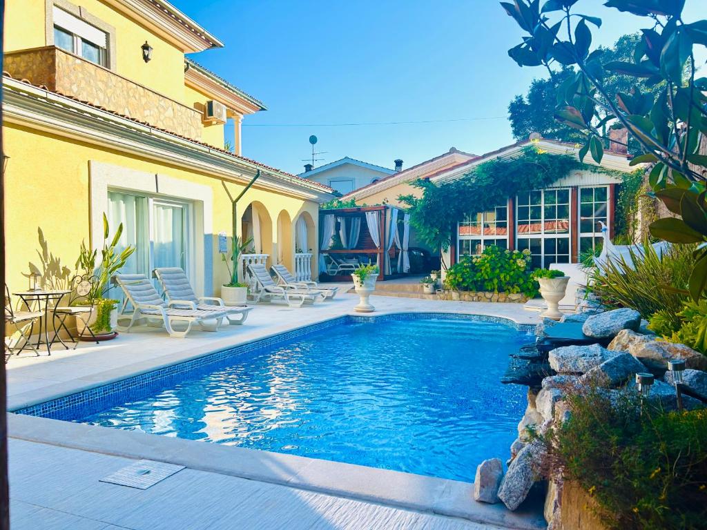 Saltwater pool, sun loungers and yellow Mediterranean villa at Sunrise Villa Alvorada in Vila Nova de Poiares