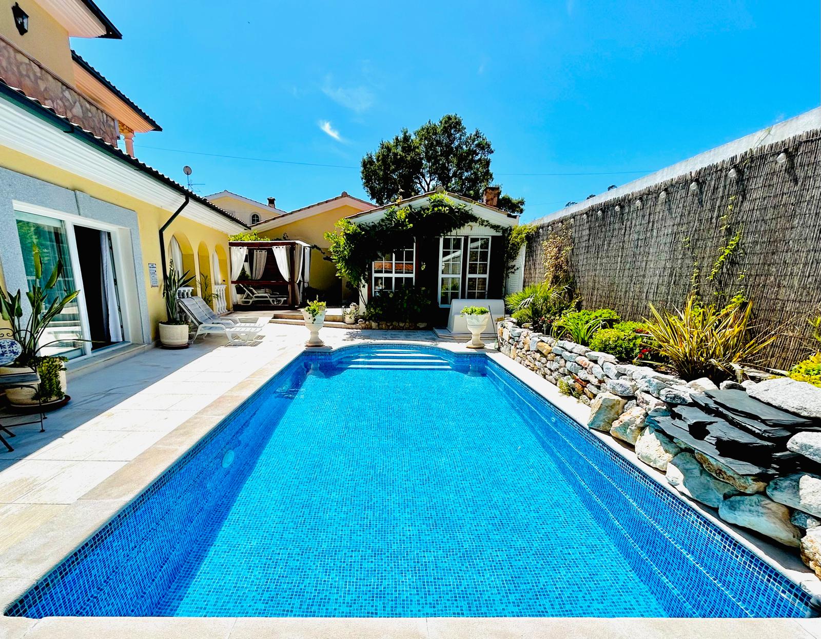 Long view of the saltwater pool with rock garden and cabana